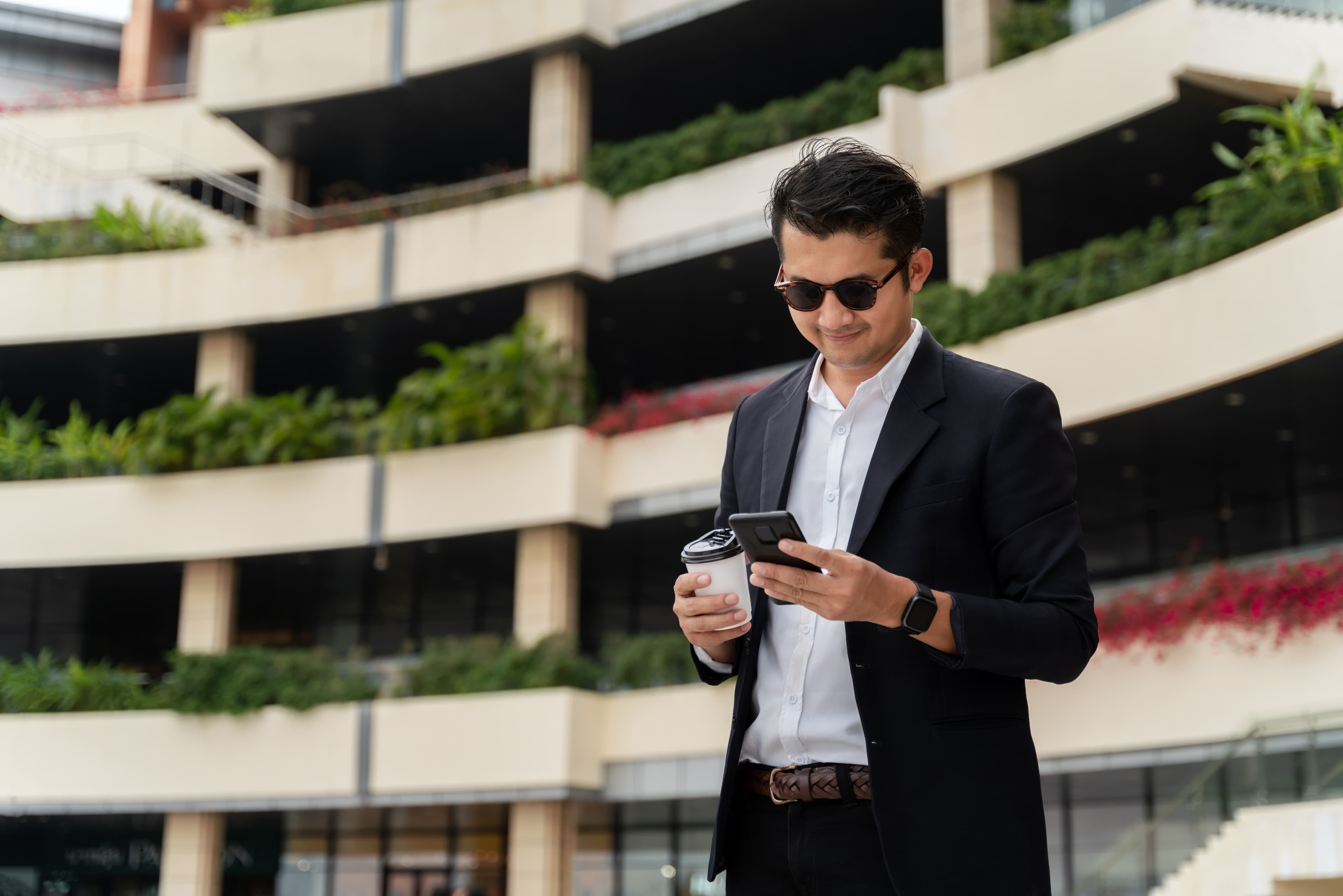 Support specialist standing on a city street with a laptop