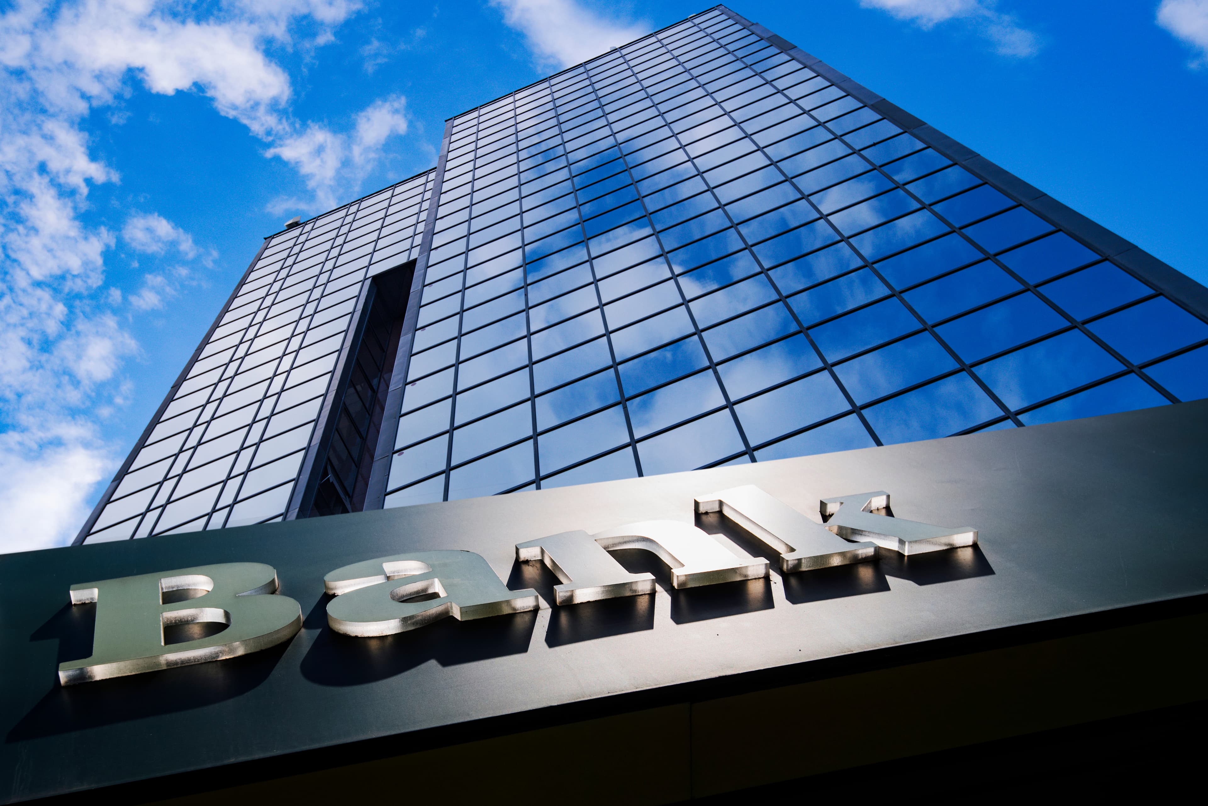 A glass office tower viewed from below