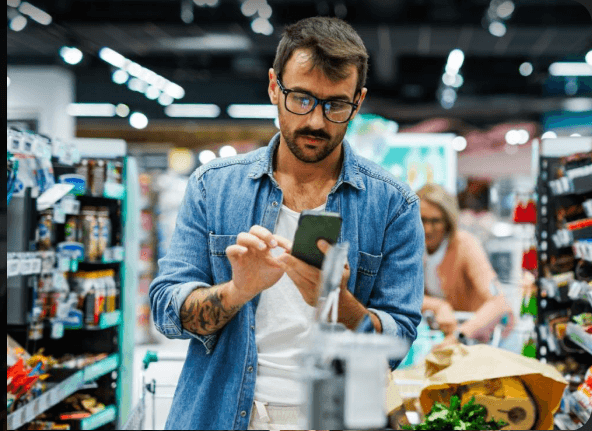 Shopper using a phone in a grocery aisle