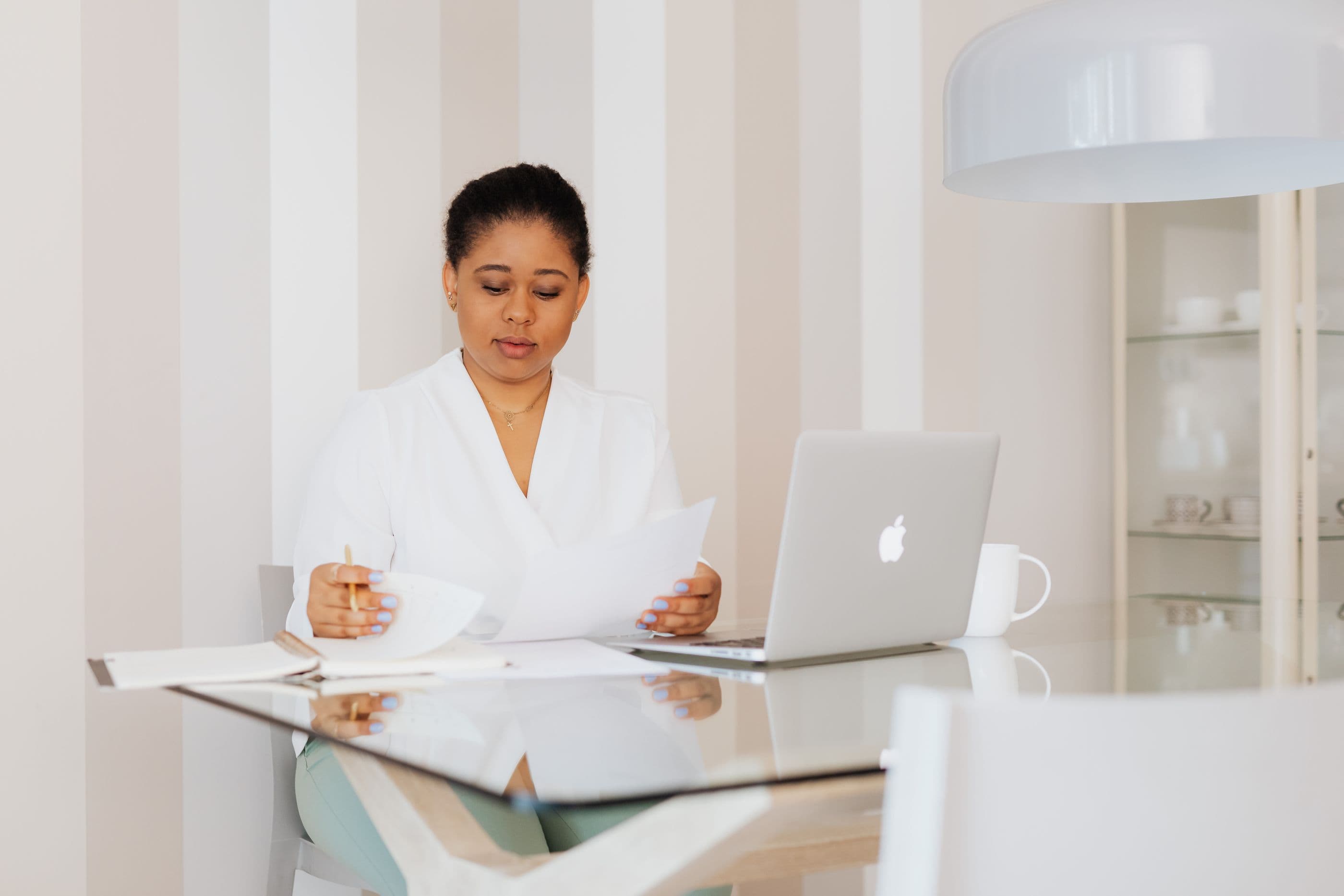 Advisor reviewing documents beside a laptop