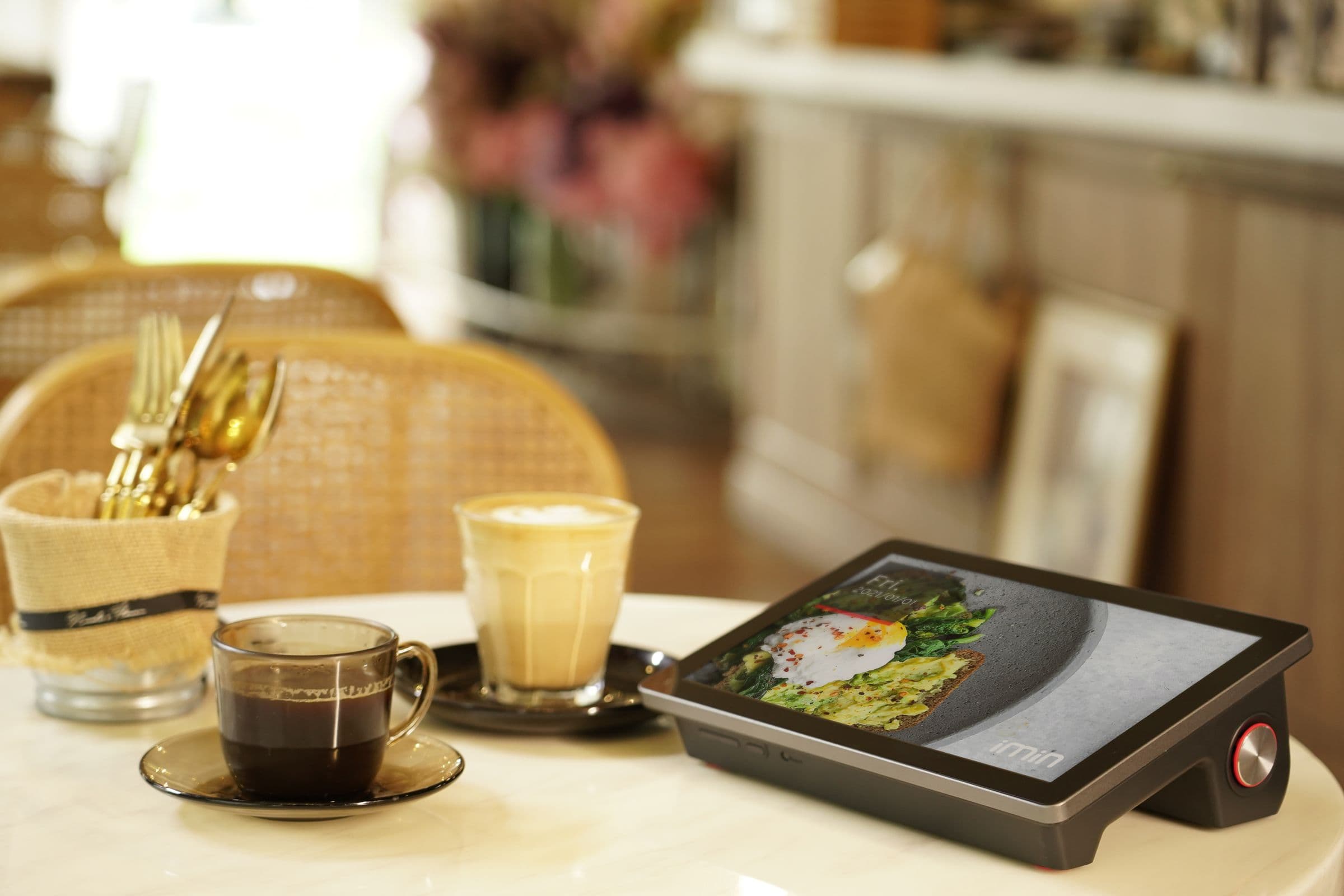 Coffee, pastry, and a tablet on a cafe table
